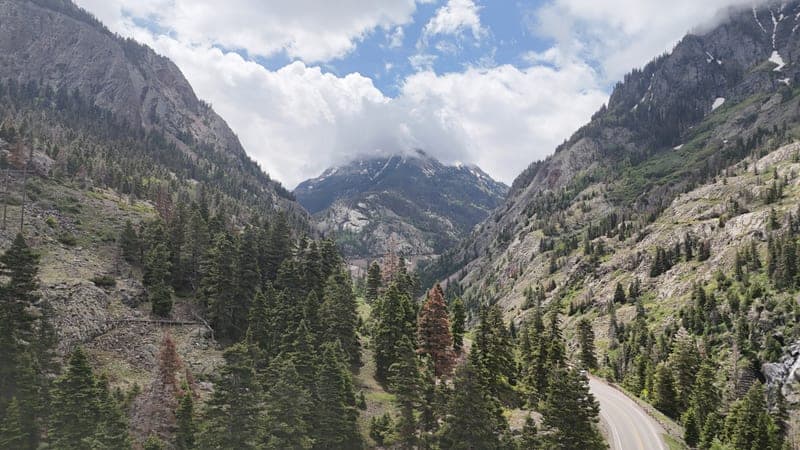 A forested valley falling away toward a far ridge.